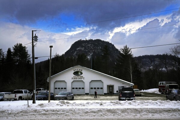 A voter watches her footing as she walks across the snow-covered parking lot after voting in the presidential primary election, Tuesday, Jan. 23, 2024, in Stark, N.H. The town's polling site, located in the volunteer fire dept., sits is in the shadow of Devil's Slide Mountain. (AP Photo/Robert F. Bukaty)